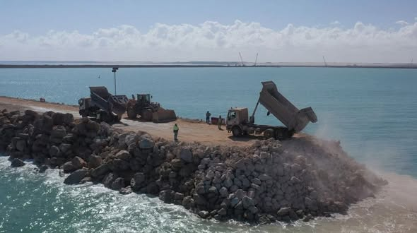 Trucks tipping breakwaters for Dakhla Atlantic Port